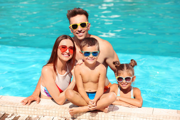 Happy family in swimming pool on sunny day