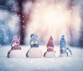 little snowmans on soft snow on blue background