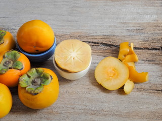 Close-up ripe Persimmon delicious fruit on wood texture background.