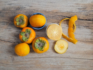 Close-up ripe Persimmon delicious fruit on wood texture background.