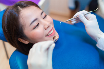 Closeup smile of woman having dental teeth examined dentist check-up via excavator in Clinic her patient