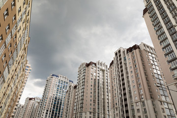 Cloudy weather, autumn sky with dark clouds. Many apartment buildings standing in front of each other