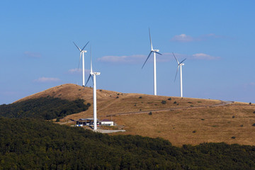 Wind generators in the mountains. Blue sky and white clouds for background.