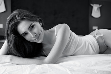 Young redheaded woman half-naked lying on the bed.