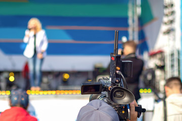 The operator shoots a concert performance on the street scene during the day