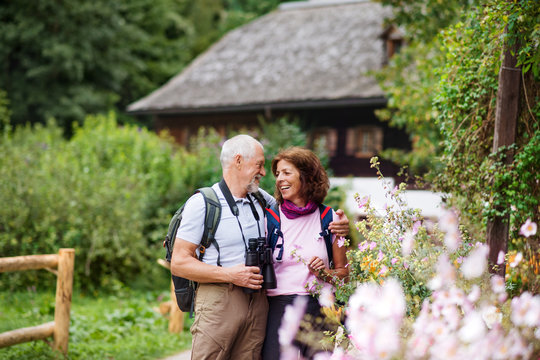 A senior pensioner couple with binoculars hiking, resting. Copy space. - Powered by Adobe