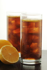 Glasses with cuba libre cocktail or cola with ice or cold tea with lemon