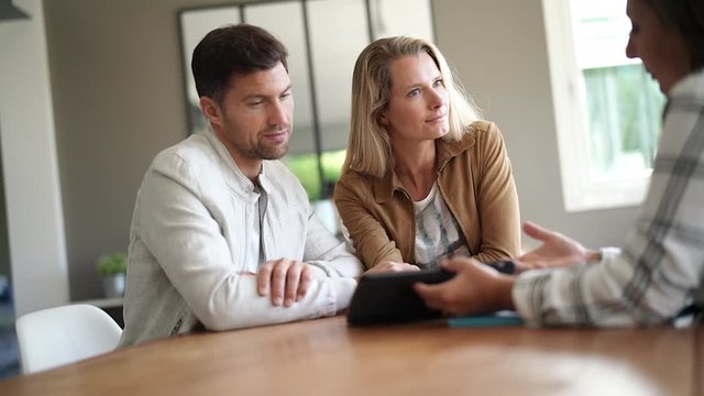 Couple meeting real-estate agent in office