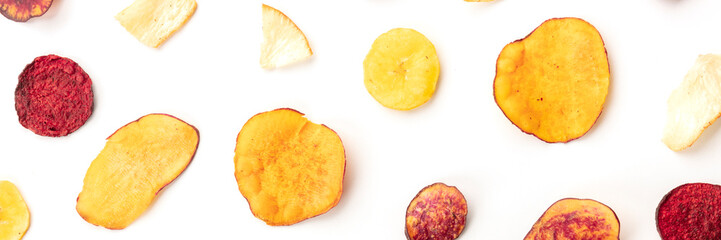 A panorama of dry fruit and vegetable chips, shot from the top on a white background. Healthy vegan...