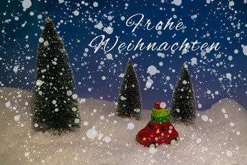 Fototapeta na wymiar Toy car in the snowy night, Christmas card with the German words for merry Christmas