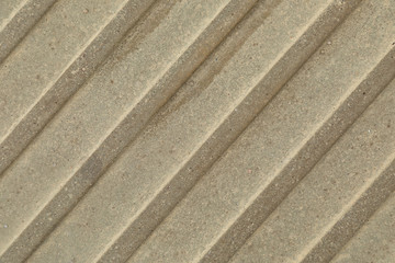 Close-up of beige-grey beton surface with diagonal stripes