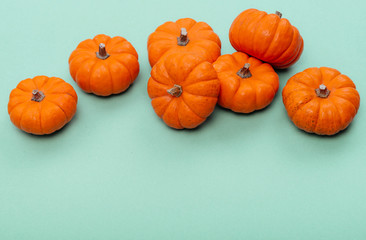 Pumpkins over neo mint background. Autumn, Halloween concept.Copy space for text.