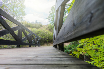 dark wooden bridge over river in a mountain forest