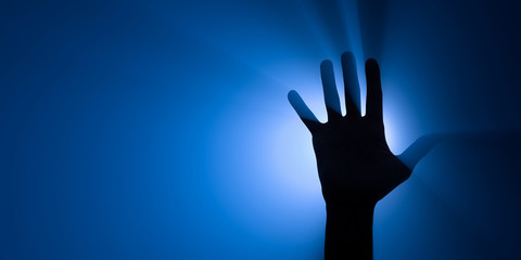 Blue spotlight behind a raised hand