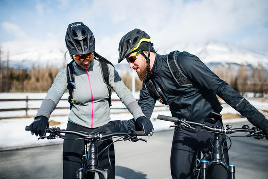 Two mountain bikers riding on road outdoors in winter. © Halfpoint