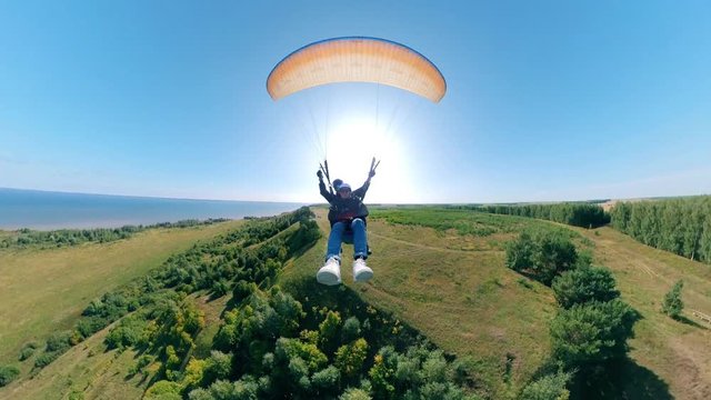 Two people are flying on the parawing in a front view