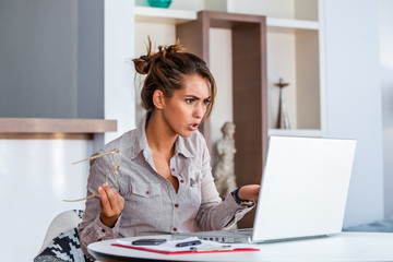Young businesswoman misunderstanding her laptop at her desk in office. woman working with laptop at...