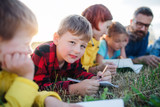 Group of school children with teacher on field trip in nature.