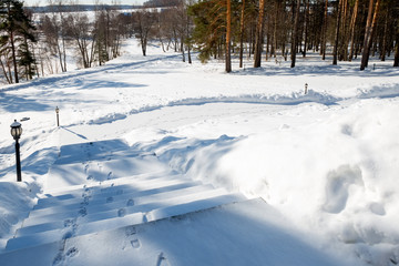 The steps on the lawn go down to the river on a sunny winter day