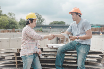 Engineers shaking hands at construction site.