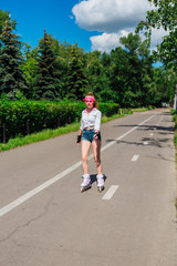 Portrait of an emotional girl in a pink cap visor and protective gloves for rollerblades and...