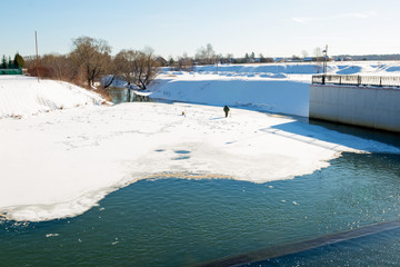 MOSCOW REGION, RUSSIA - MARCH 2, 2019: Fisherman goes ice fishing on the river Rozhayka on a winter day