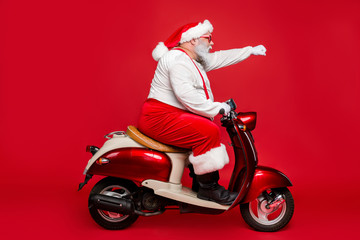 Profile side view portrait of nice bearded serious purposeful Santa Claus father riding moped...