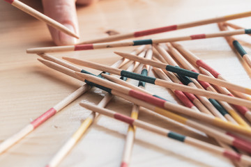 Picking up a wood pick-up stick from a random pile in Mikado game