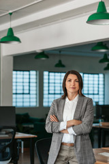 Confident businesswoman standing with her arms crossed in an office