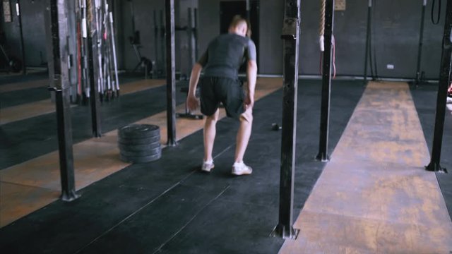 Jumping squats at gym. Effective exercises for great shape. lunch short workout. Back view to powerlifting jumps. Male fitness instructor showing jump exercise at loft plase.