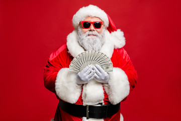 Portrait of cool strylish elderly santa claus hipster millionaire have cash want buy presents spend on winetr season sales discount wear cap hat eyewear eyeglasses isolated over red background © deagreez