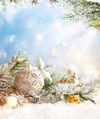 Christmas winter background with Christmas baubles and fir tree branches on snow.