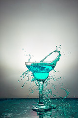 Glass with blue champagne or cocktail. Levitation