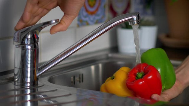 Paprika Gem&uuml;se wird unter Wasserhahn gewaschen
