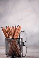 Group of school supplies pencils and books on wooden table over a grey background