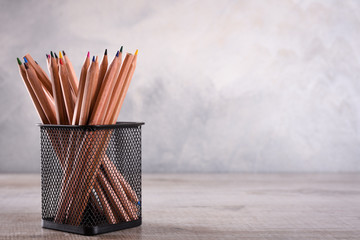 Group of school supplies pencils and books on wooden table over a grey background