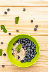 Oatmeal porridge with fresh blueberry, mint leaves and yogurt