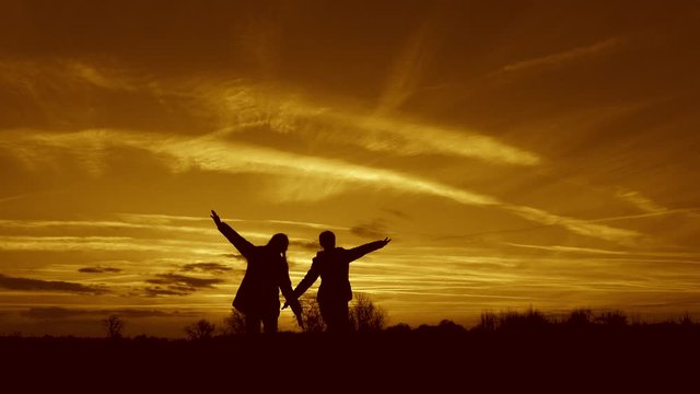 Children play in evening at sunset. concept of a happy childhood. children dream of flying. Superhero girls running through the meadow against backdrop of a beautiful sky. girlfriend teamwork