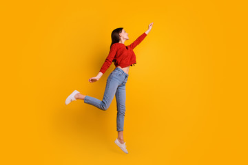 Fototapeta na wymiar Full length photo of positive cheerful lovely girl jump hold hand want catch her flying parasol star wear good looking clothing isolated over yellow color background