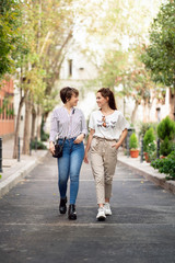 Fototapeta na wymiar Young female couple walking and laughing in the street