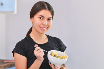 Beautiful Smiling Woman Eating Fresh Organic Fruit Salad In Kitchen