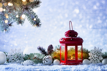 Christmas lantern in snow with fir tree branch and holiday decorations. Winter cozy scene.