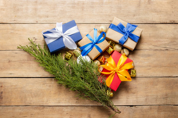 Gifts, Christmas decorations and a sprig of Christmas tree on a wooden background. The concept of a winter mood, Christmas, winter holidays. Flat lay, top view