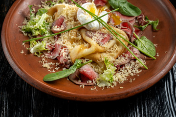 Diet menu. Salad with chopped steak, poached eggs, pancakes, green salad. Sprinkled with grated cheese.