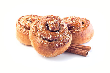 Three cinnamon buns and cinnamon sticks isolated on  white background