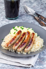 Roasted nuremberg sausages served with sour cabbage and mashed potatoes, vertical