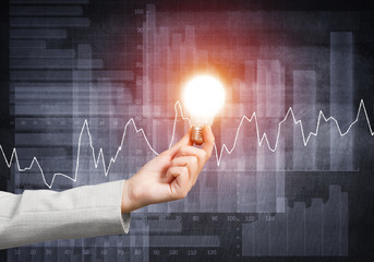 Woman hand holding glowing light bulb