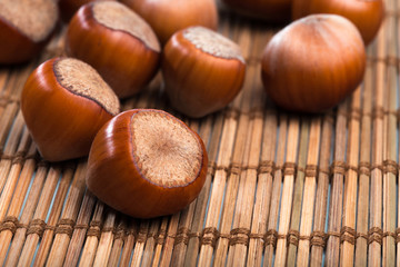 close up of hazelnuts on wooden table .