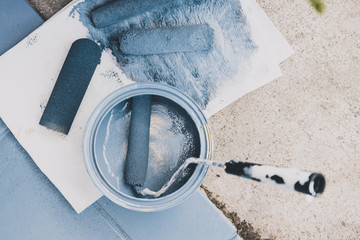 empty tin of muted blue paint next to newly painted tfloor tiles