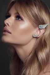 Beautiful young woman with kaffa in the ear. Make up and Jewelry concept - Image